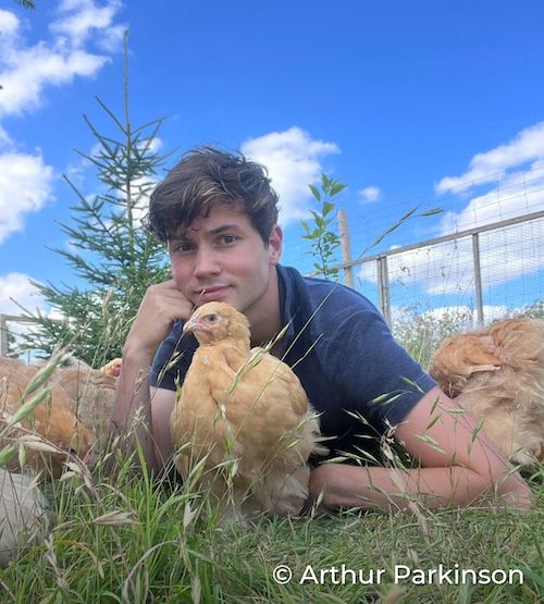 Arthur, CIWF supporter, laying on the ground with his chickens